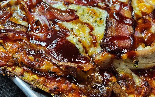 BBQ Chicken Bandit Pizza with mesquite grilled chicken, bacon, red onion and BBQ sauce - Monte Bello Pizzeria